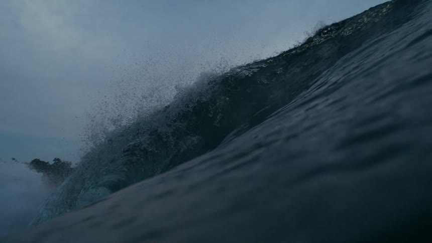 At sundown the ocean creates a large wave causing a strong splash