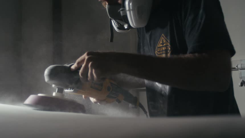 A man is sanding with a electric sander