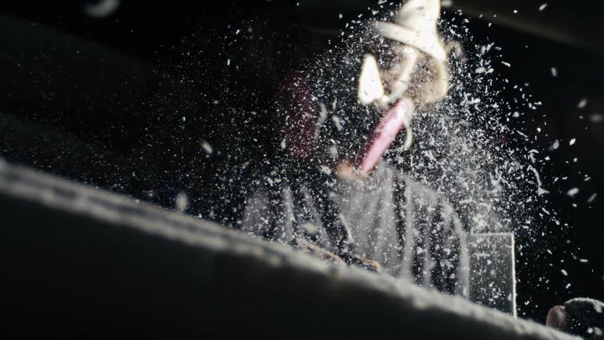Man in cap concentrating polishing a surfboard