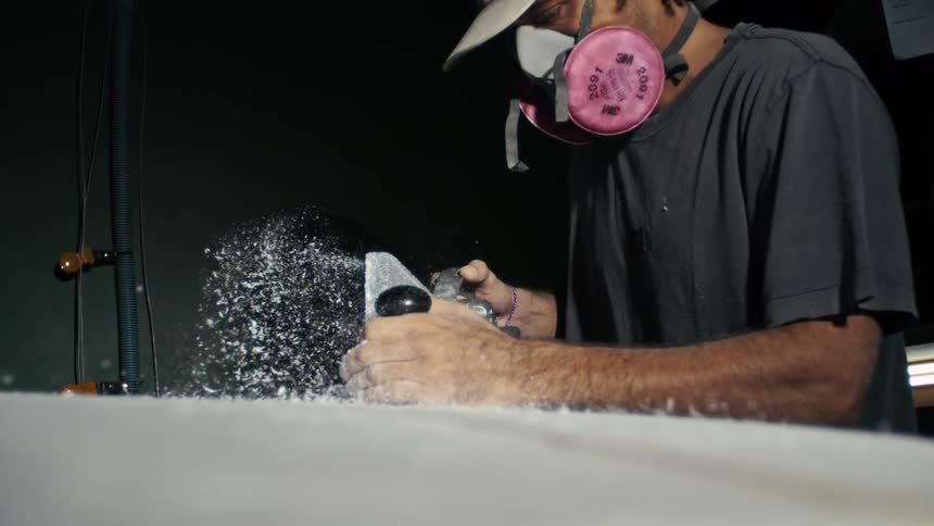 Man polishing and crafting a surfboard