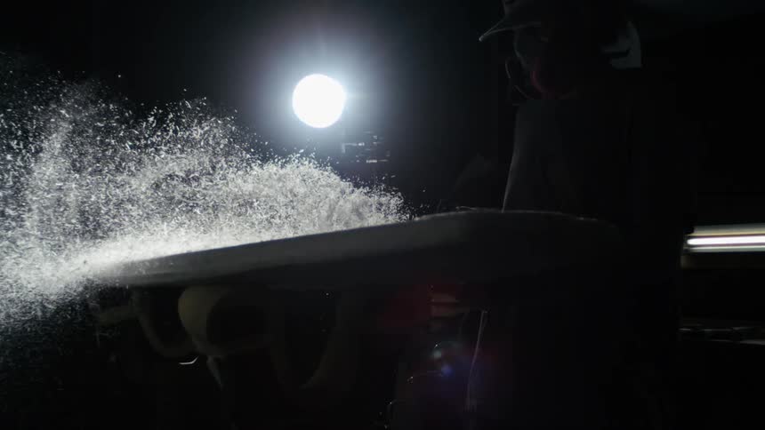 A person uses a tool to create sawdust
