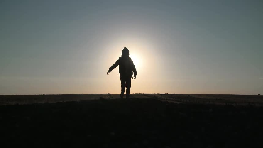 Child running through a field on a sunny day