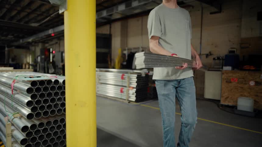Man carrying metal in a factory