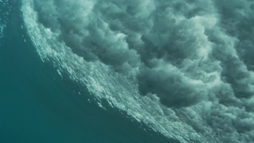 A murky underwater moment shows bubbles and waves