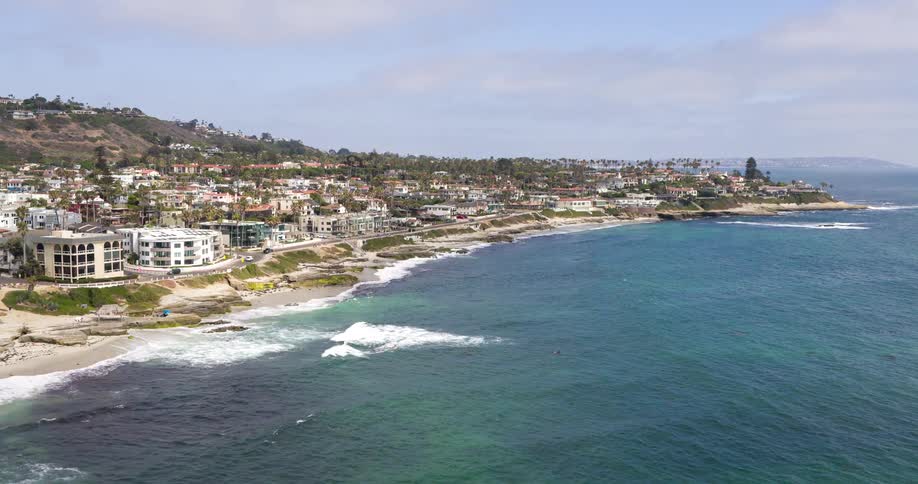 Flying over the ocean adjacent to a coastal town