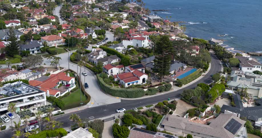 A picturesque coastal neighborhood with upscale homes lining the cliffs overlooking the ocean