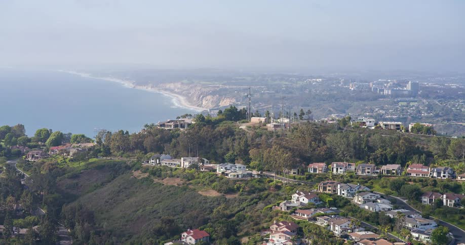 Hilltop homes overlook the ocean and an expansive beach curving into the distance