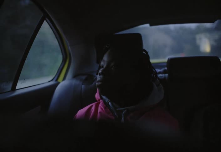 The girl is riding in the backseat of the car