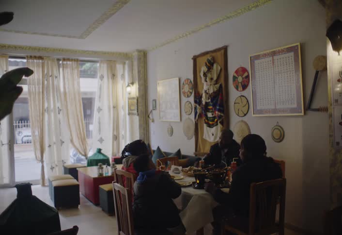 A group of people are seated at a table in a restaurant enjoying a meal