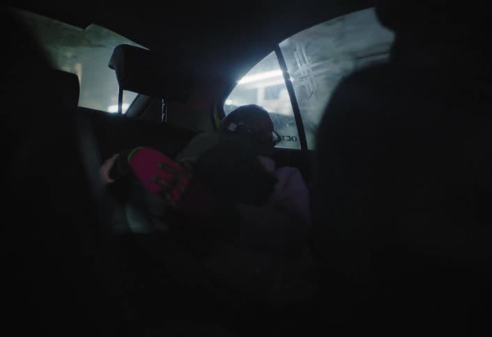Two children hug and rest while riding in the back seat of the car