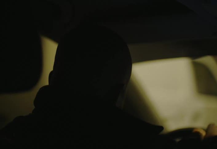 The man drives past the building at night