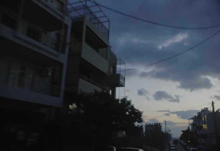 Driving down a street looking up at the buildings and sky