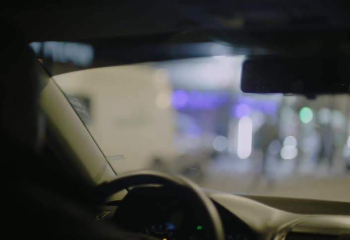 The man drives in the city at night