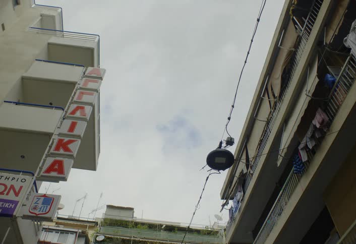 The bird flies on the sign by the apartments