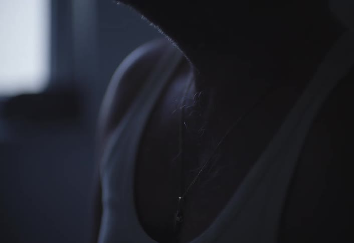 A man touches the pendant around his neck