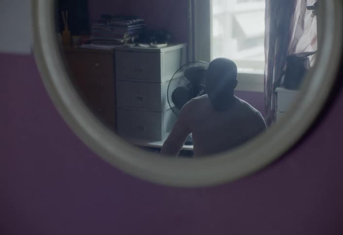 Reflection of a man seen through a mirror in a room of the house