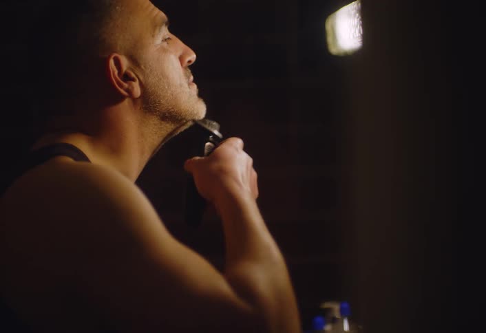 Man shaving in the living room of the house