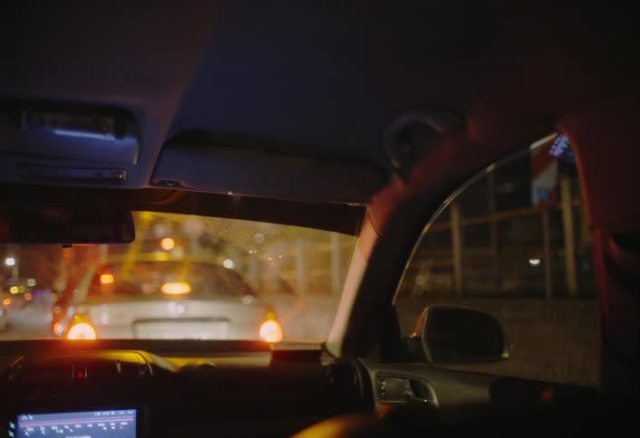 View from inside a car at night with a train passing by