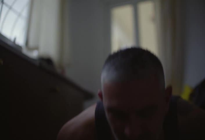 A man performs push ups indoors during a bodyweight workout