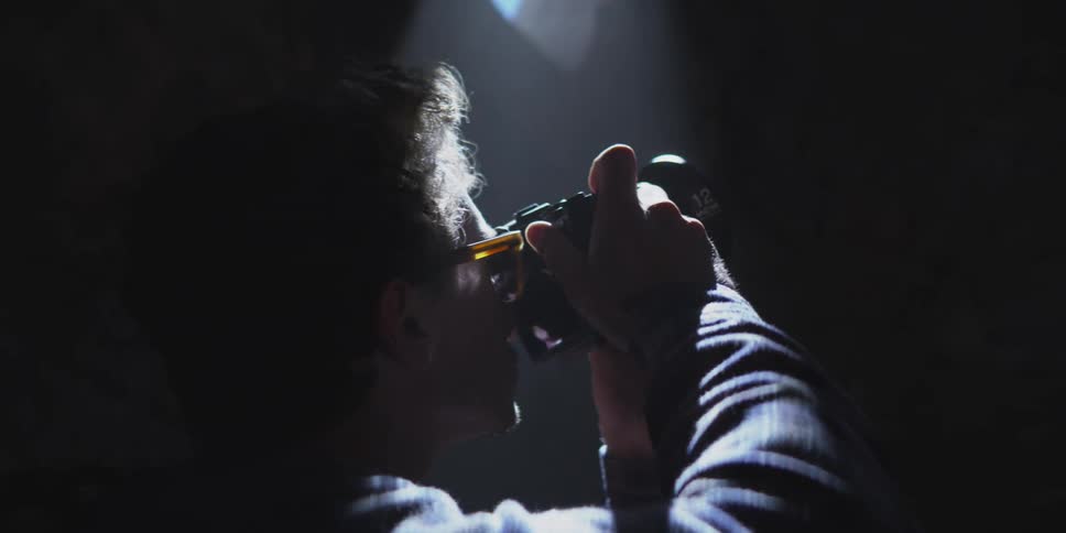 Man taking a picture in a tunnel with a small beam of light