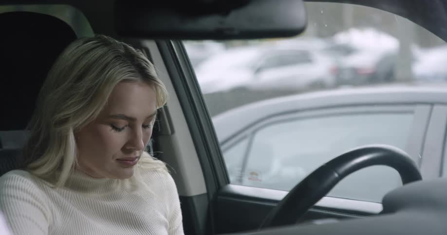 Woman getting into the car running her hands through her hair and huffing