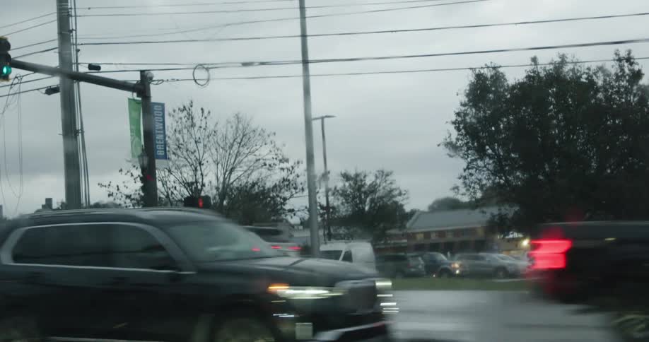 Cars move through heavy traffic at an intersection beside a plaza