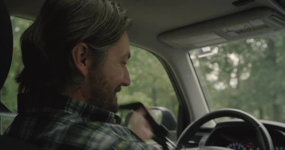 A man drives a car and prepares to stop and exit