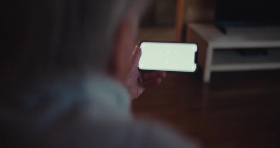 Elderly man vibrating with joy holding a smartphone