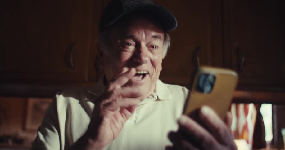 Elderly man laughing and talking on a smartphone
