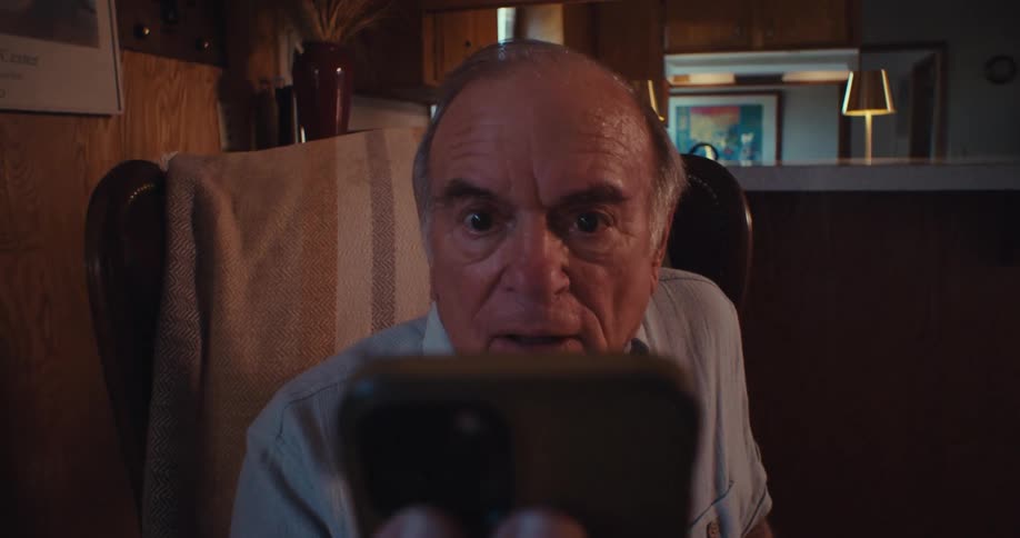 The video features a closeup shot of an elderly man with a concerned expression looking directly at the camera he is sitting in what appears to be a living room setting