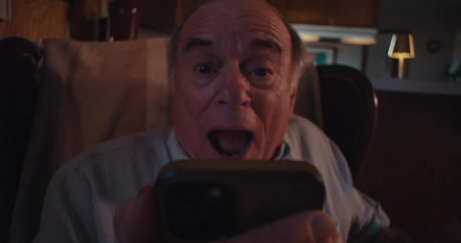 Man looks at phone with excitement and happiness