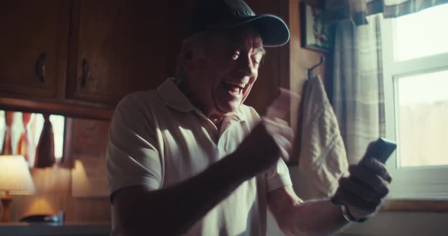Elderly man happily chatting on a video call on his smartphone