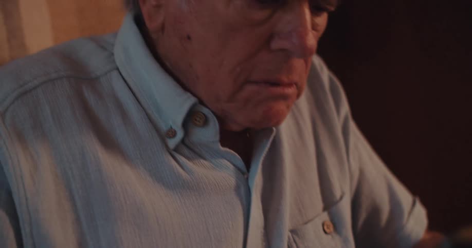 Elderly man sitting holding a smartphone