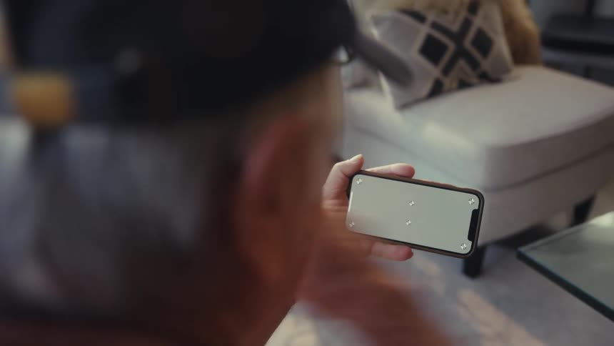 Elderly man excitedly plays and wins a game on his smartphone