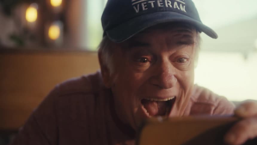 Elderly man wearing a cap shouting and vibrating with happiness