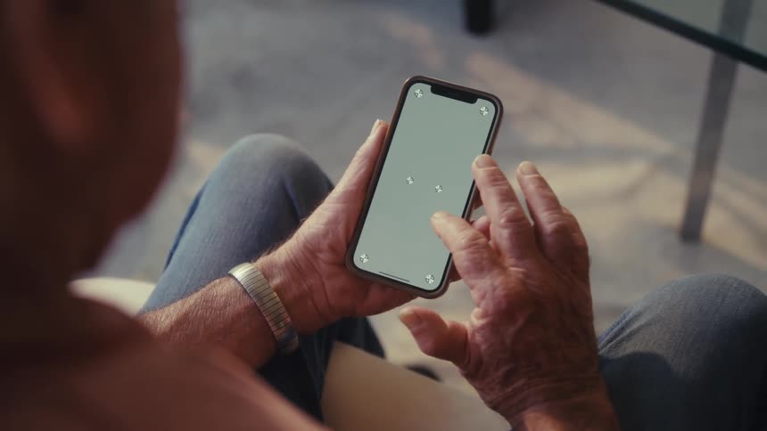 Hands of an elderly person interacting with a smartphone