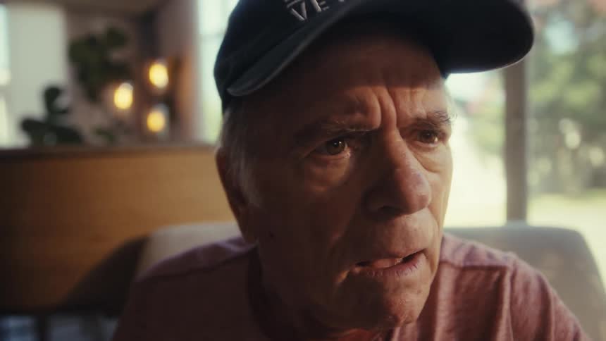 Older man looks at phone with a shocked expression