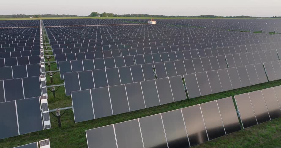 Stacked rows of solar panels are aligned towards the morning sun at dawn