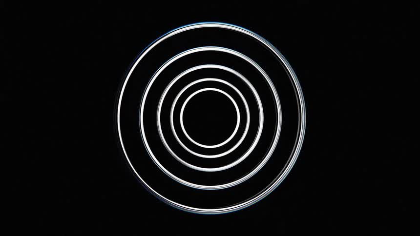 The video features a shiny abstract metallic sculpture with flowing layered forms the camera rotates around the sculpture highlighting its smooth reflective surfaces and intricate curves