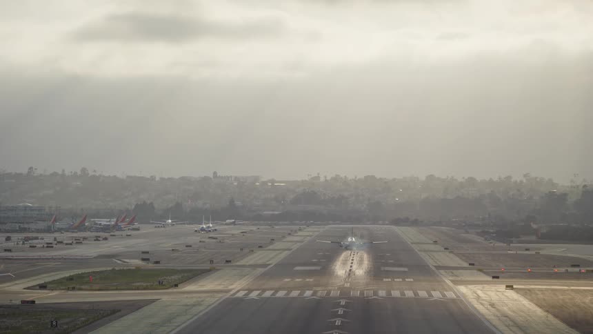 Airplane on a cloudy day landing on an airport runway