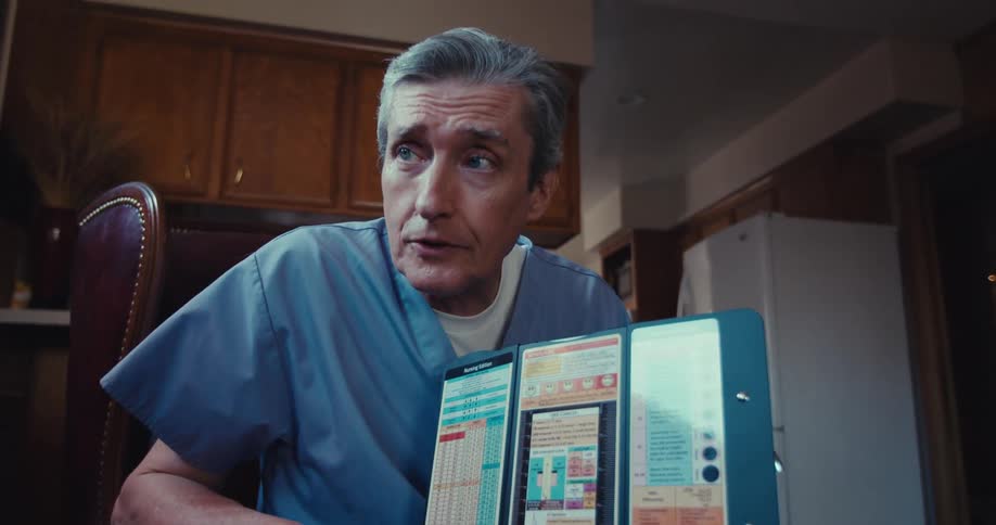 A male nurse sits and talks to a patient showing medical information on a tablet