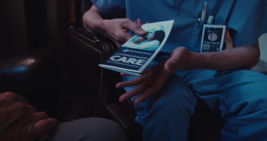 Nurse handing out a pamphlet with a booklet to a patient