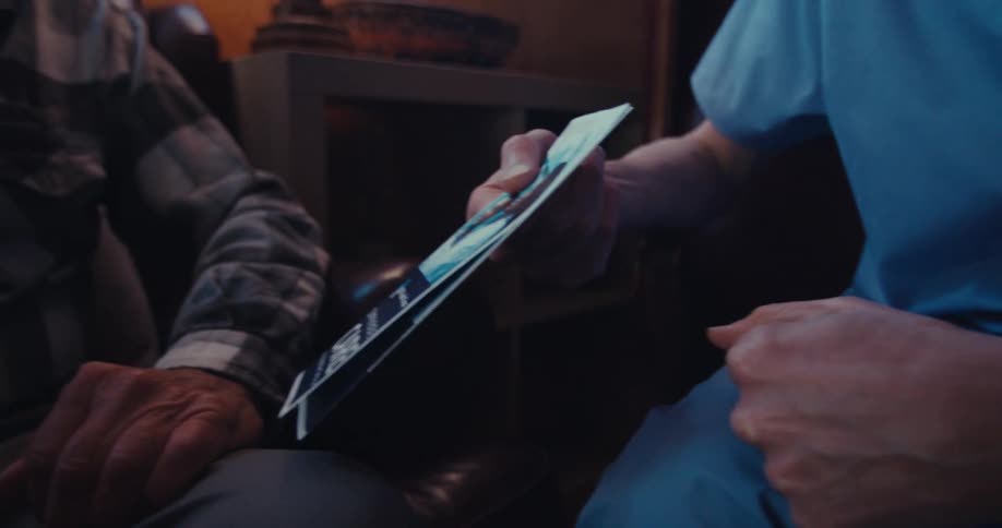 Pair of hands of a doctor handing a pamphlet to a patient
