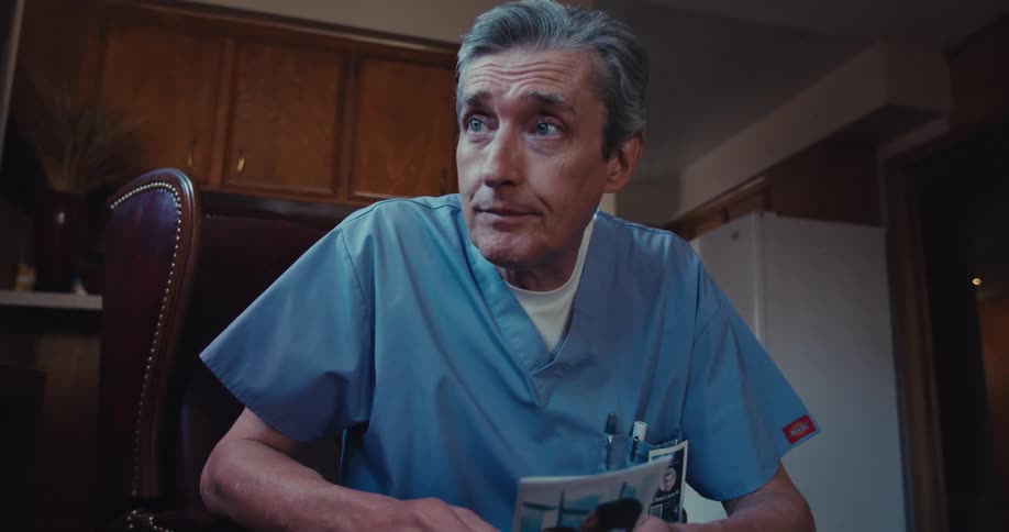 A male nurse sits and talks to a patient showing medical flyer