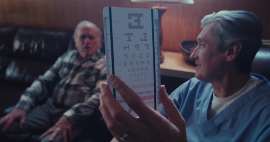 A doctor is showing a patient an eye chart