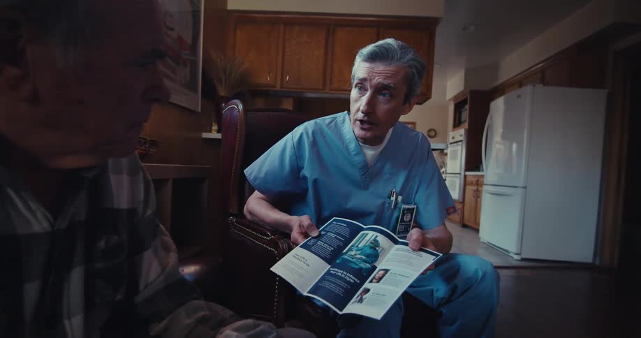 Doctor presenting a pamphlet to an elderly gentleman