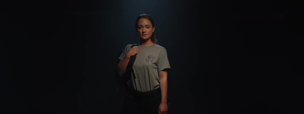 A young woman holding a backpack spinning 360 degrees to reveal her appearance
