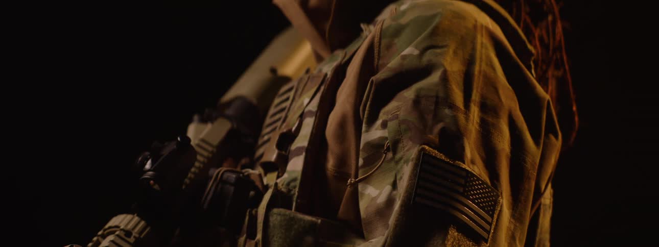 A soldier is pointing a rifle down
