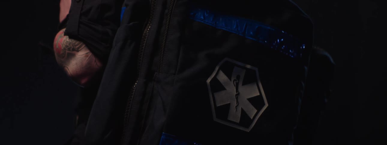 Close up of a male healthcare personnel carrying a bag in a dark room