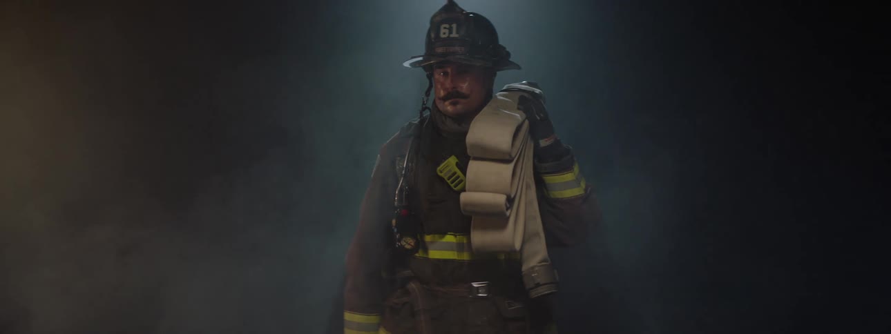 The firefighter is standing in a room full of smoke